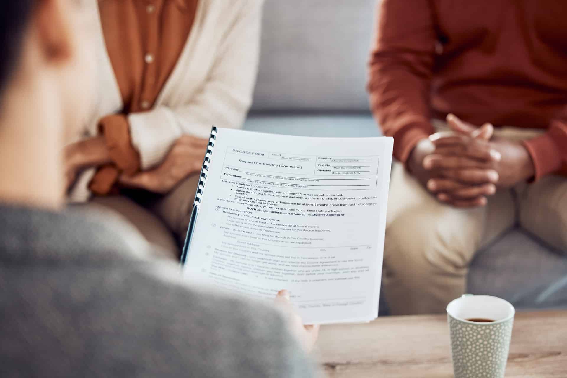 Couple, divorce form and family lawyer for therapy and documents apply for legal advice together. Meeting, marriage compliance worker and conversation with application contract on sofa in office.