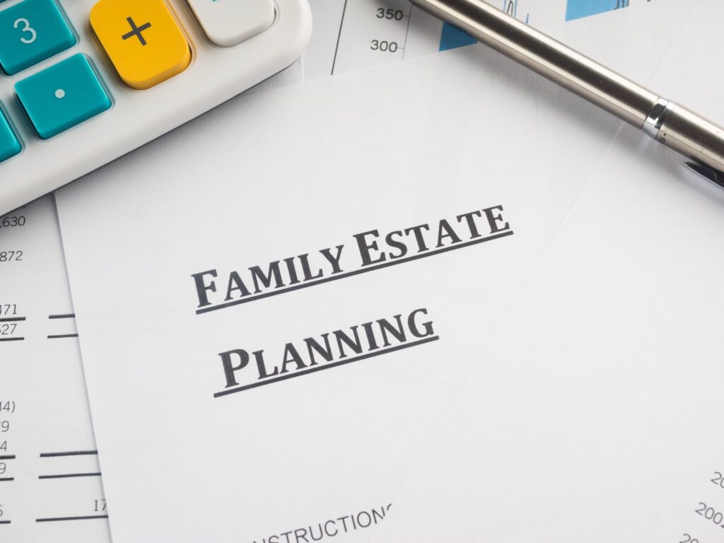 A calculator next to a pen and paper that say family estate planning