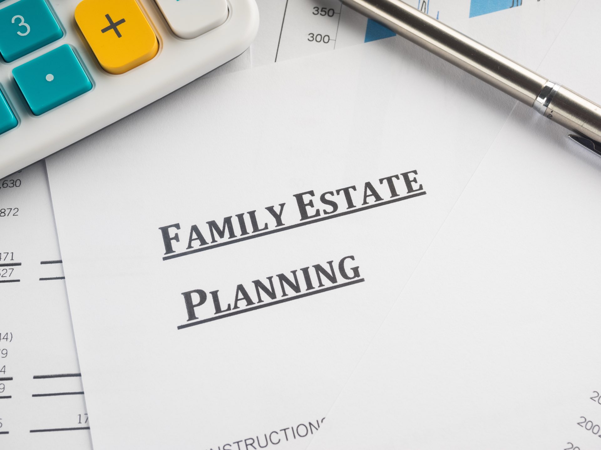 A calculator next to a pen and paper that say family estate planning